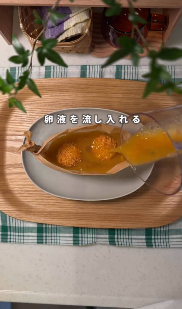 冷凍カツと卵液を流し入れる