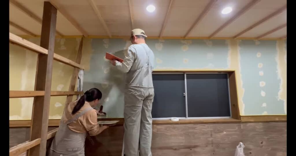 夫婦2人がかりでパテを壁に盛る