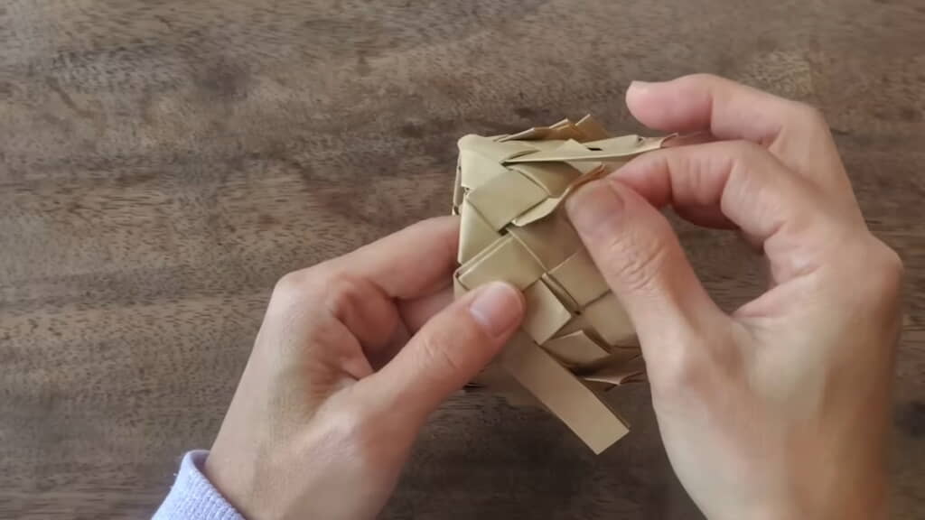 縁で折り返した帯の端を編み目に差し込む