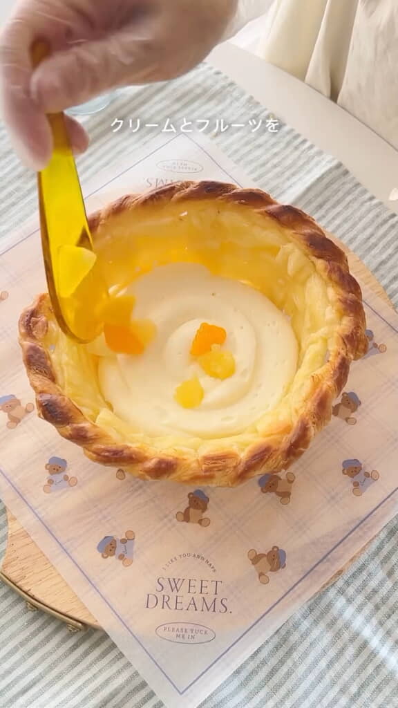 パイのバスケットの中にスポンジケーキとクリーム、フルーツを入れる