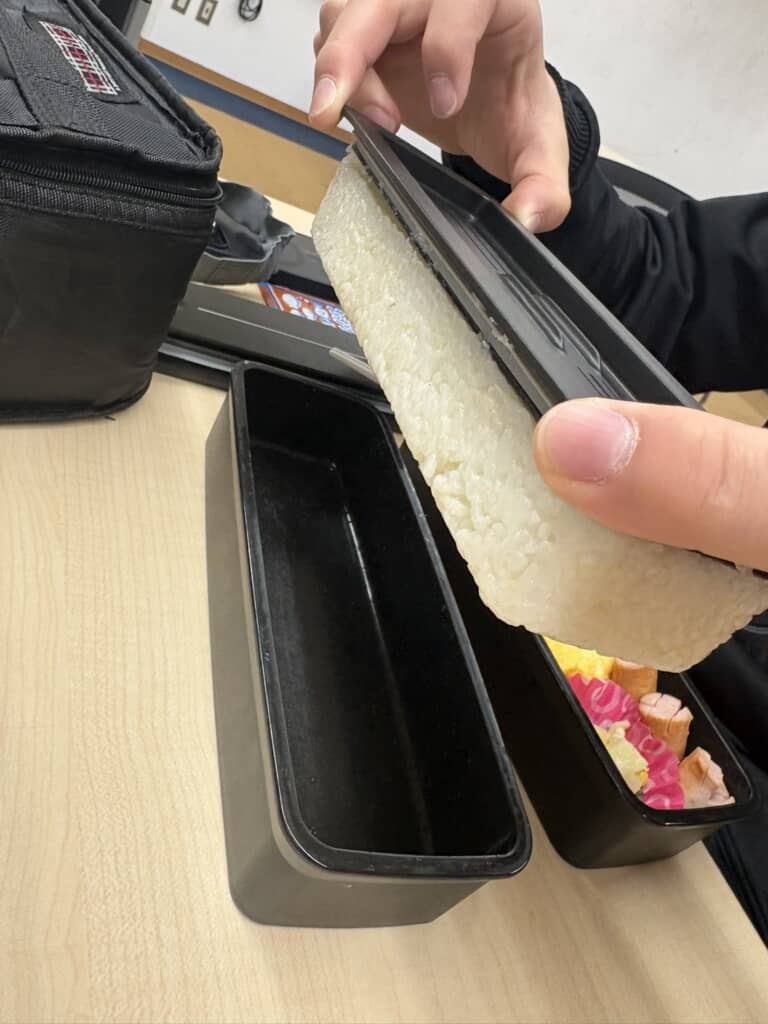 お弁当箱の蓋に白米がすべてついてしまっている様子。 
