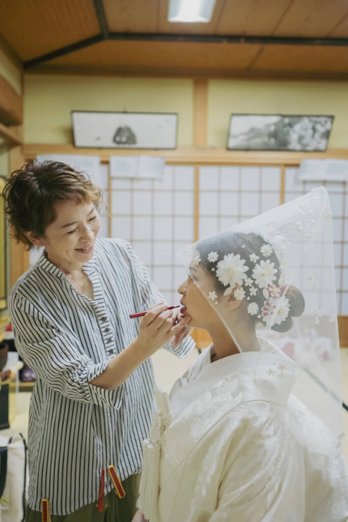 母が娘に紅を入れる、なんともエモーショナルな一枚