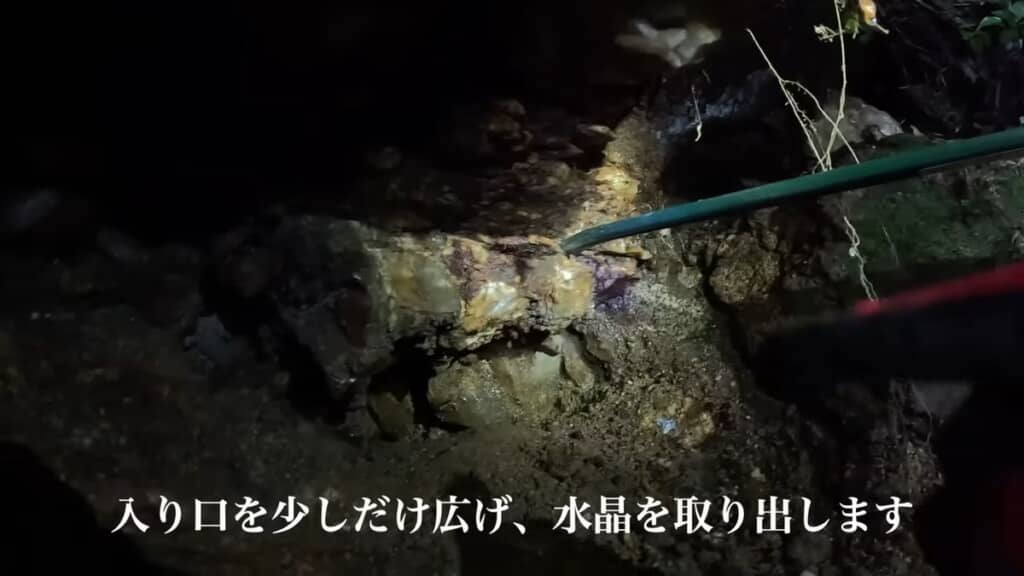 バールとハンマーで水晶をガマから剥がす様子