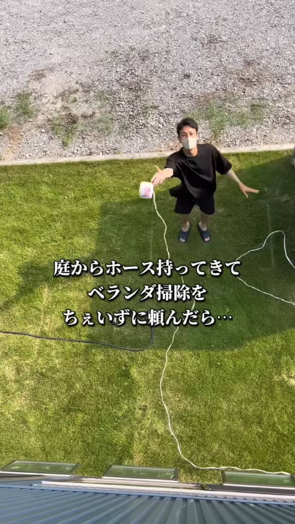 庭からホースを渡すためヒモを投げるパパさん