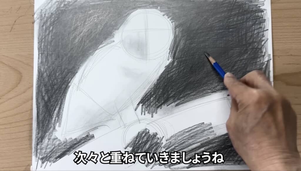 鉛筆でフクロウの背景を黒く塗りつぶしている制作過程