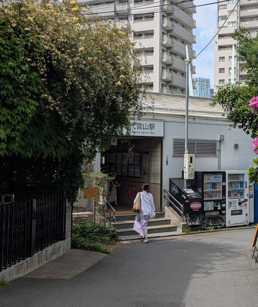 代官山駅の出入口へと向かう歩行者と周囲の街並み