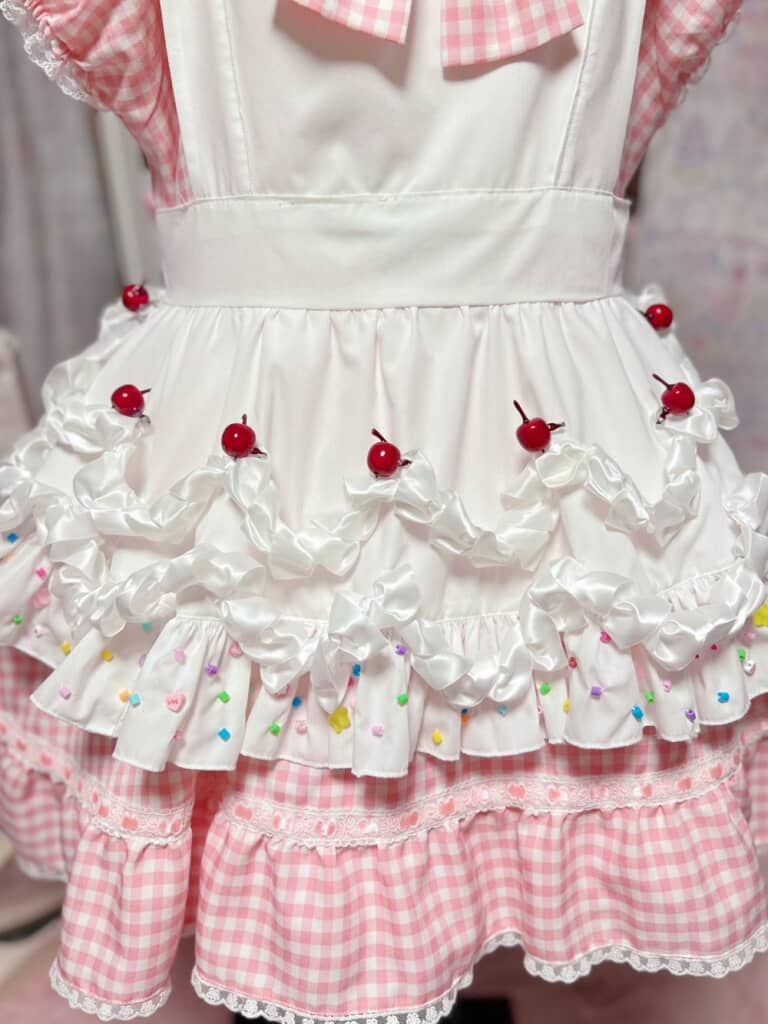 生クリームに見えるフリルはエプロンと違って光沢のある素材