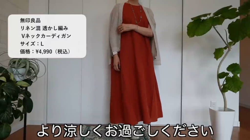 レンガカラーのワンピースに、ライトベージュの「リネン混透かし編みVネックカーディガン」を羽織ったコーデ