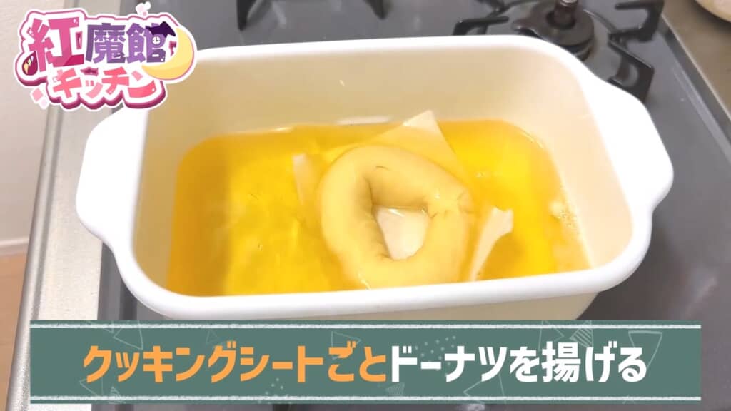 輪にしてクッキングシートの上に置き、丸ごと揚げ油へ。シートは裏返したときに外します