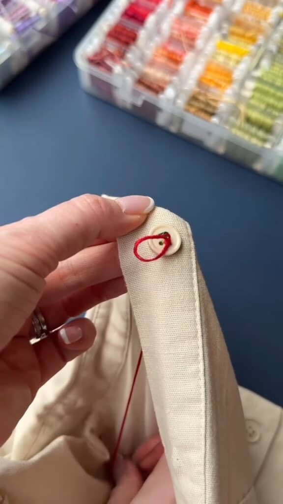 赤い糸をボタンの上へ盛り上がるようにステッチ