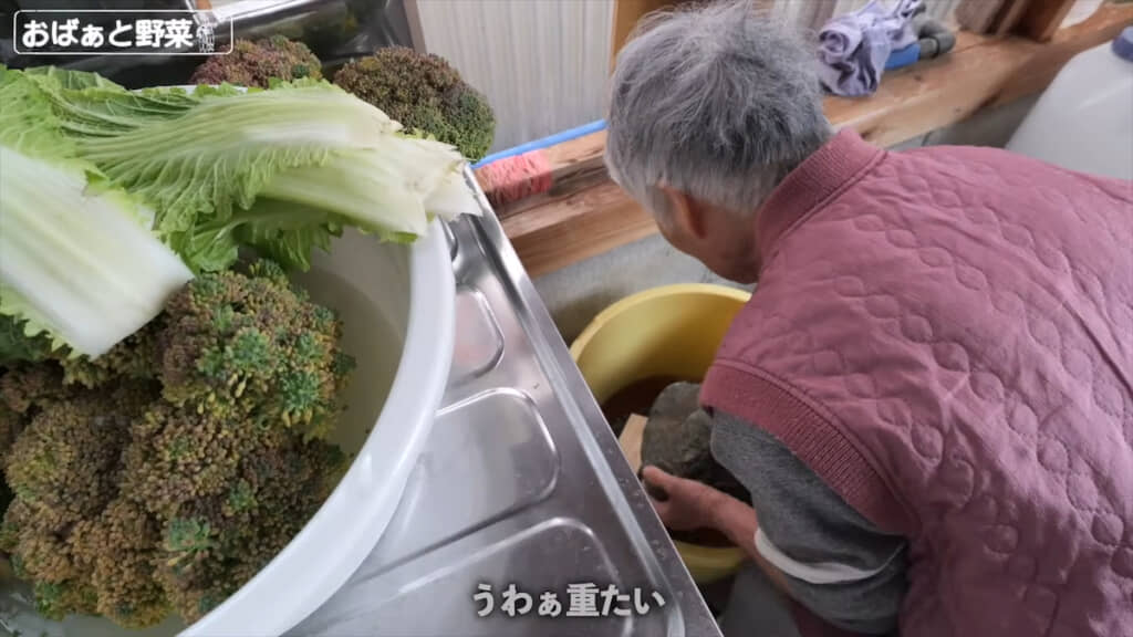 自ら率先して重し石をどかすおばあちゃん