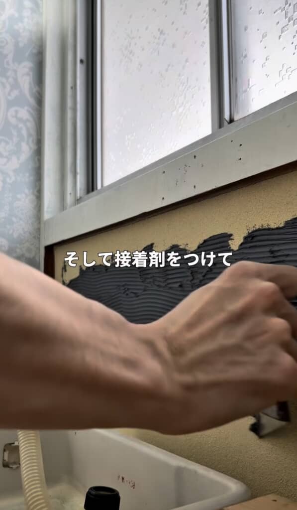 トイレのDIYで接着剤を塗りタイルを貼る様子