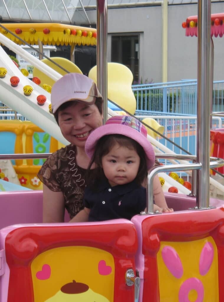 遊園地で一緒にアトラクションに乗る2人（20年前）