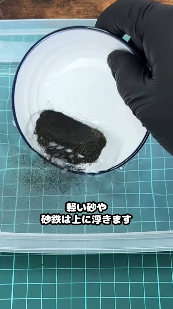 しょうゆ皿の中に砂を入れて水中で揺らす