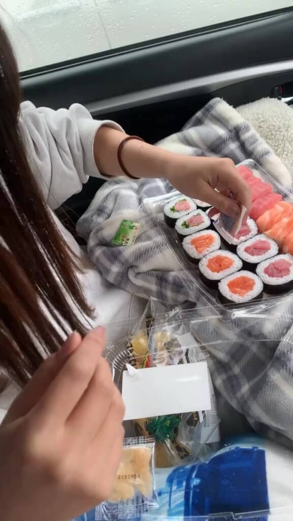 パックのお寿司を広げる彼女さん