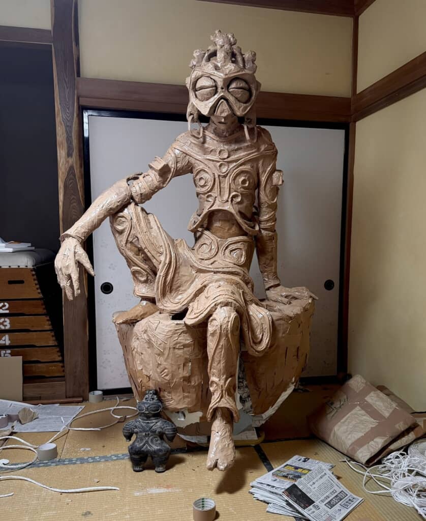 足を崩して座っている仏像のような作品