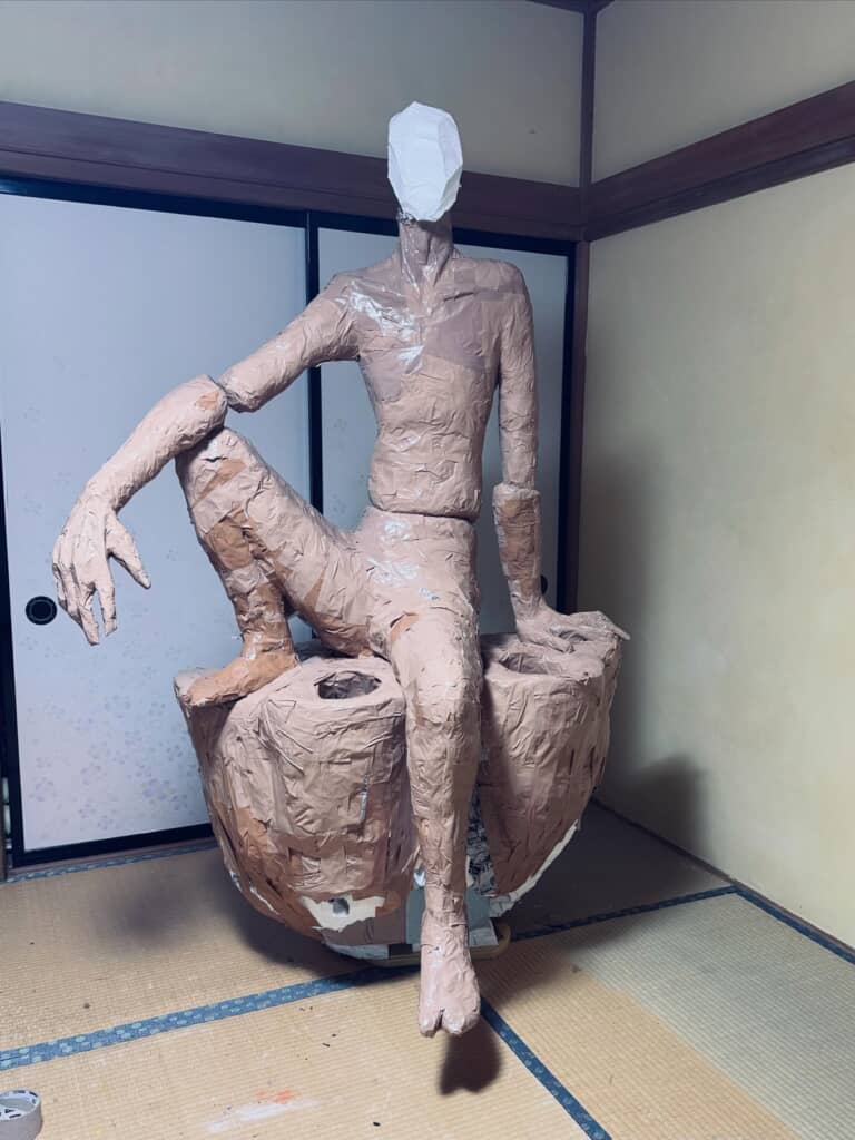 新聞紙とガムテープでグルグル巻きになった体