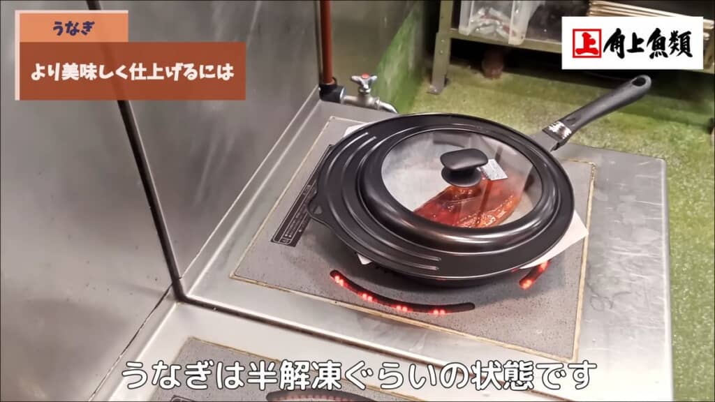 フタをしたフライパンで加熱されるウナギのかば焼き