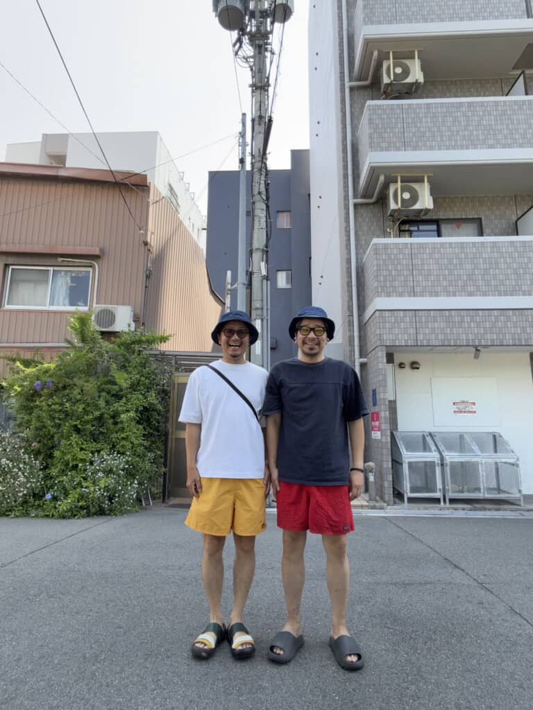 住宅街でおそろいの帽子姿の男性2人