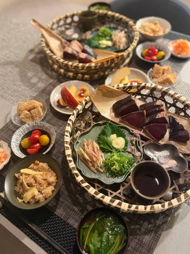 カツオのたたきを竹皮に乗せて薬味や調味料をまとめてカゴに入れるコーディネイトがおしゃれ