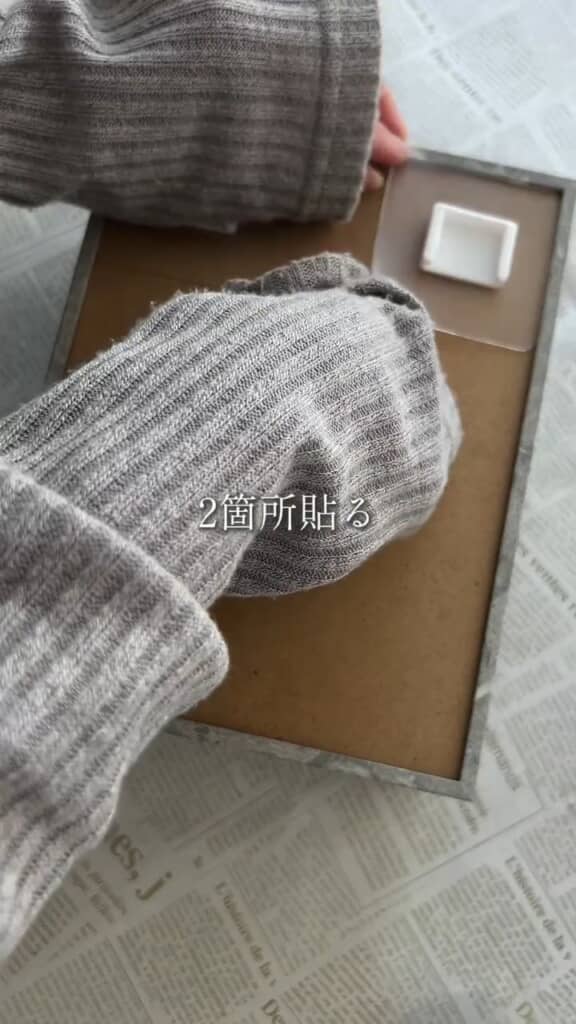 壁に設置するためのフックを付ける様子