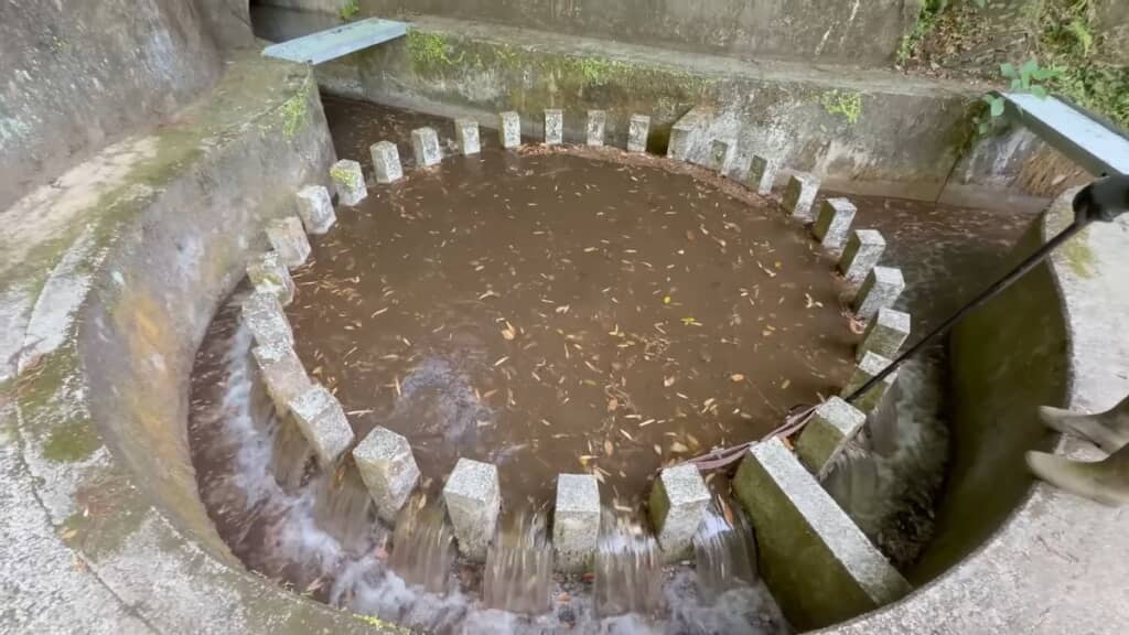 縁を通って2方向へ水が流れていく烏嶽円形分水
