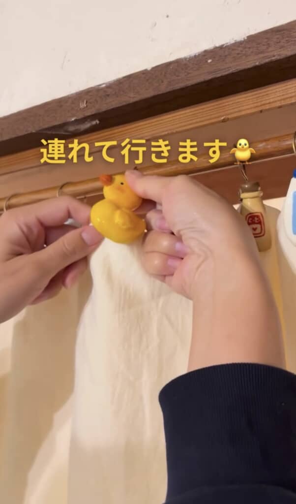 アヒルのオブジェを暖簾に取り付けている様子