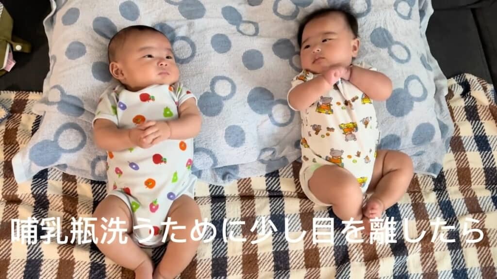 並んで寝転ぶ双子の赤ちゃん