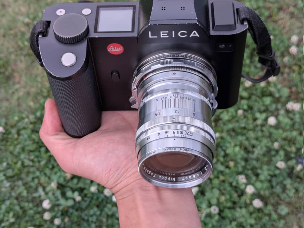 LEICA SLボディにNIKKOR-P.C 8.5cm F2レンズを装着し手に持つ様子