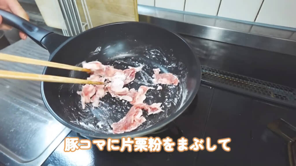 豚肉はフライパンの上で片栗粉をまぶしています