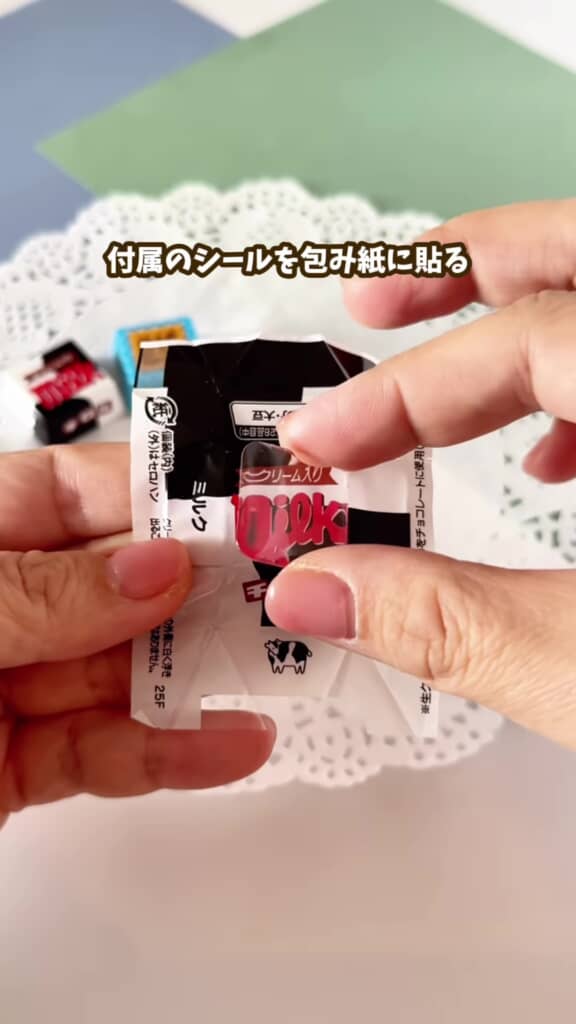 チロルチョコの包み紙にシールを貼るところ