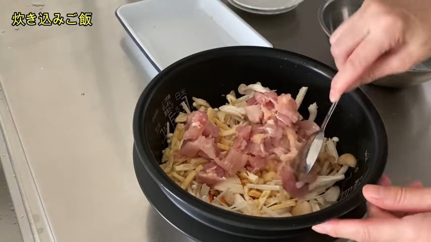 スプーンのようなもので釜の中の具材を均等にならしている