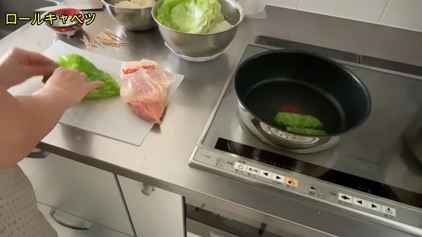 茹でたキャベツに肉だね包んではフライパンに並べている