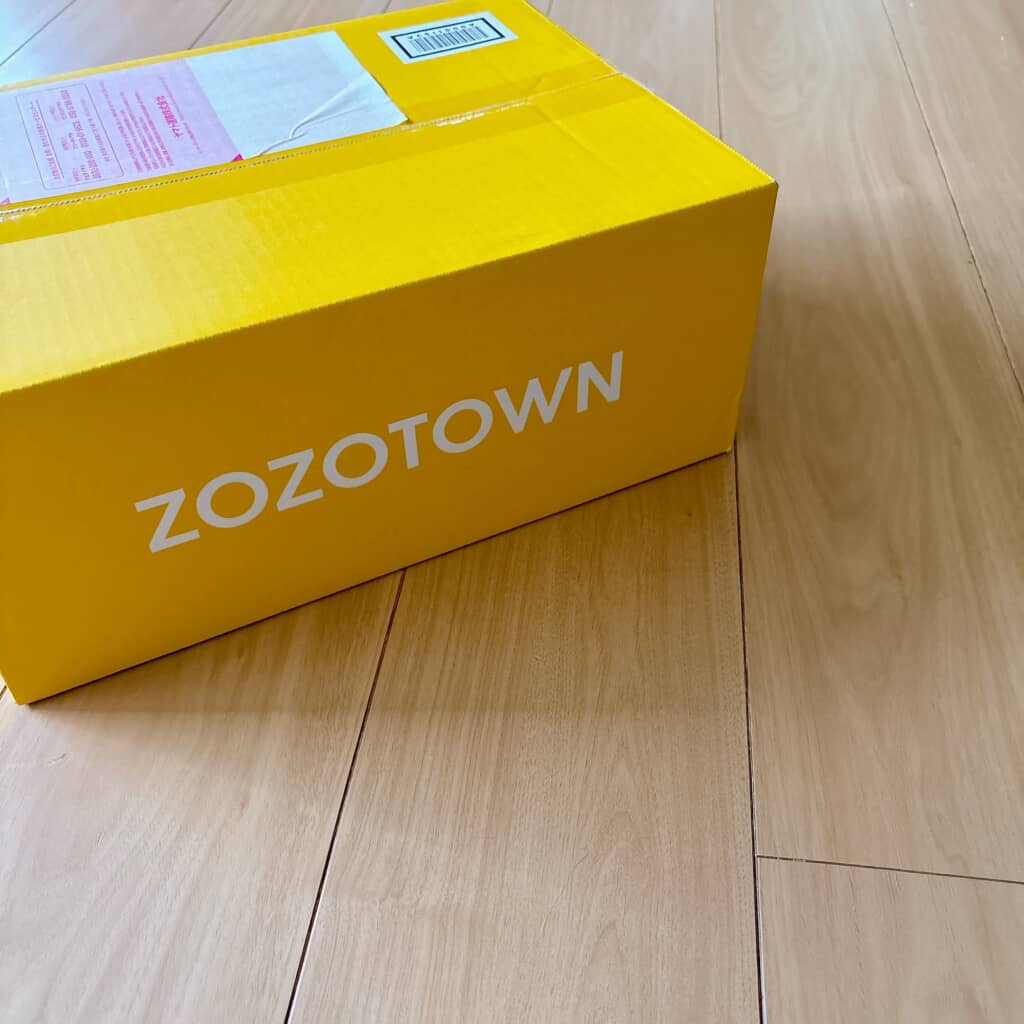 床に置かれたZOZOTOWNの黄色い配送ボックス