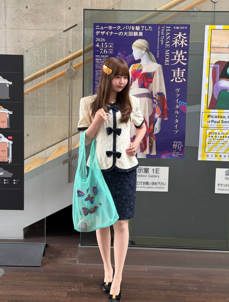 ニットにハート柄やネクタイモチーフをあしらった上品でかわいらしい一着。森英恵の展示会へその衣装で足を運び、30年の時を超えて受け継がれた魅力を披露した