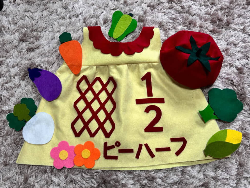 キューピーハーフをかたどったベビー服。画像編集で隠されていますが、本来「キュー」が入る場所にはお孫さんの名前が入っているそうです