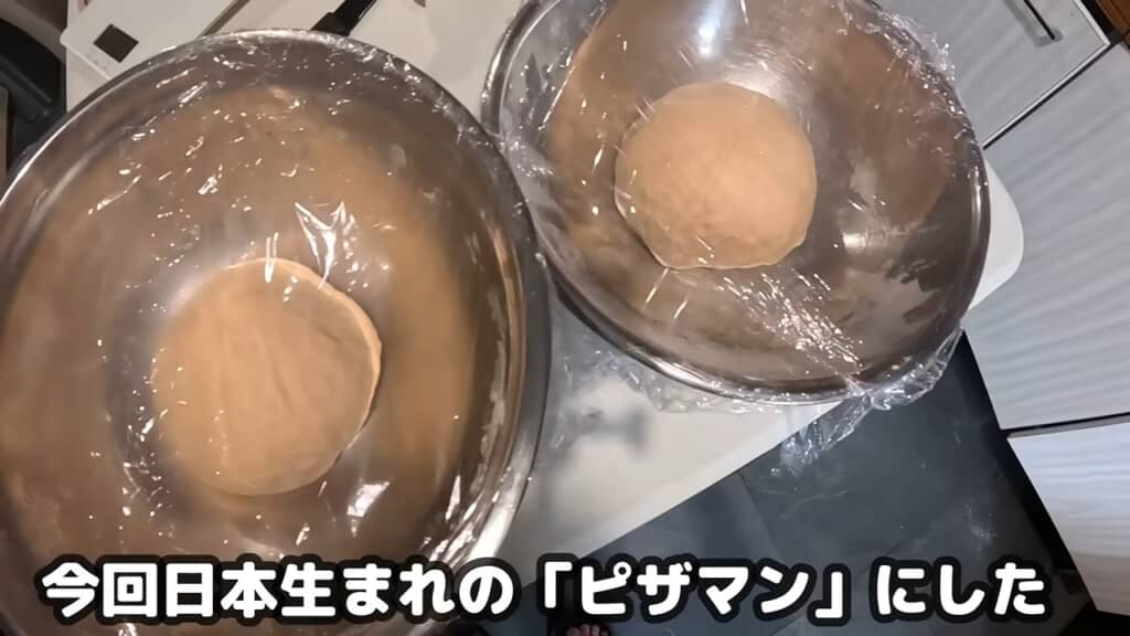 ボウルの中で発酵させたピザまんの生地2個、ラップをかけた状態