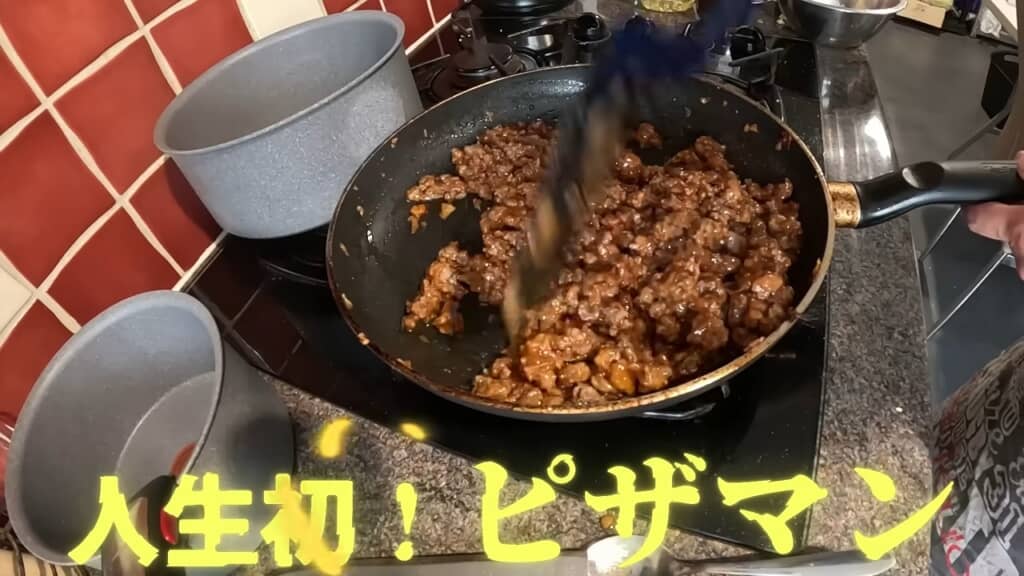 フライパンで炒めた具材が茶色く煮詰まったピザまんの中身、人生初ピザマンの文字