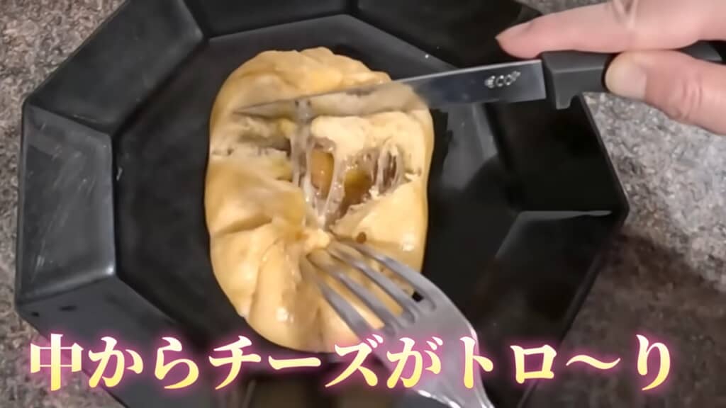 ナイフで切ったピザまんの断面からチーズがとろけて溢れる様子