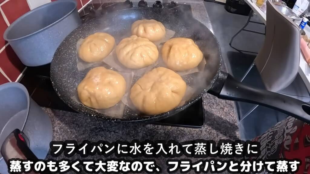 フライパンに水を張り蒸し焼きにする成形済みピザまん6個、湯気が立つ様子