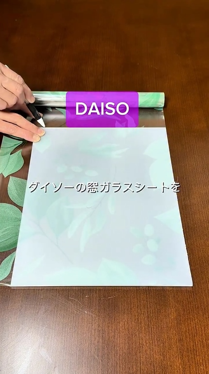 窓ガラスシートにPPシートを当てて、ペンで線を引いています