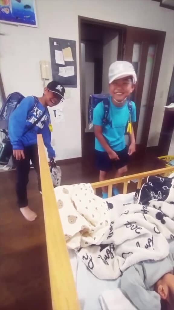 ベビーベッドの前のお兄ちゃんたち