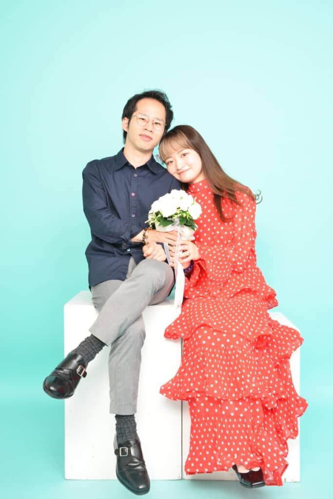 赤いドットのワンピースで丸尾さんと一緒に白いブーケを持つ由羽さん