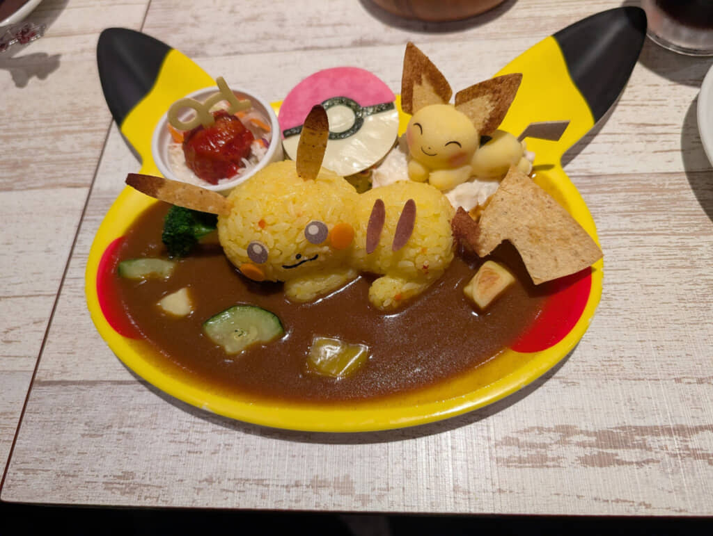 ピカチュウとピチューがのったかわいいカレー。モンスターボール型の豆腐ハンバーグや、「クラボのみ」に見立てたミートボールのサラダも