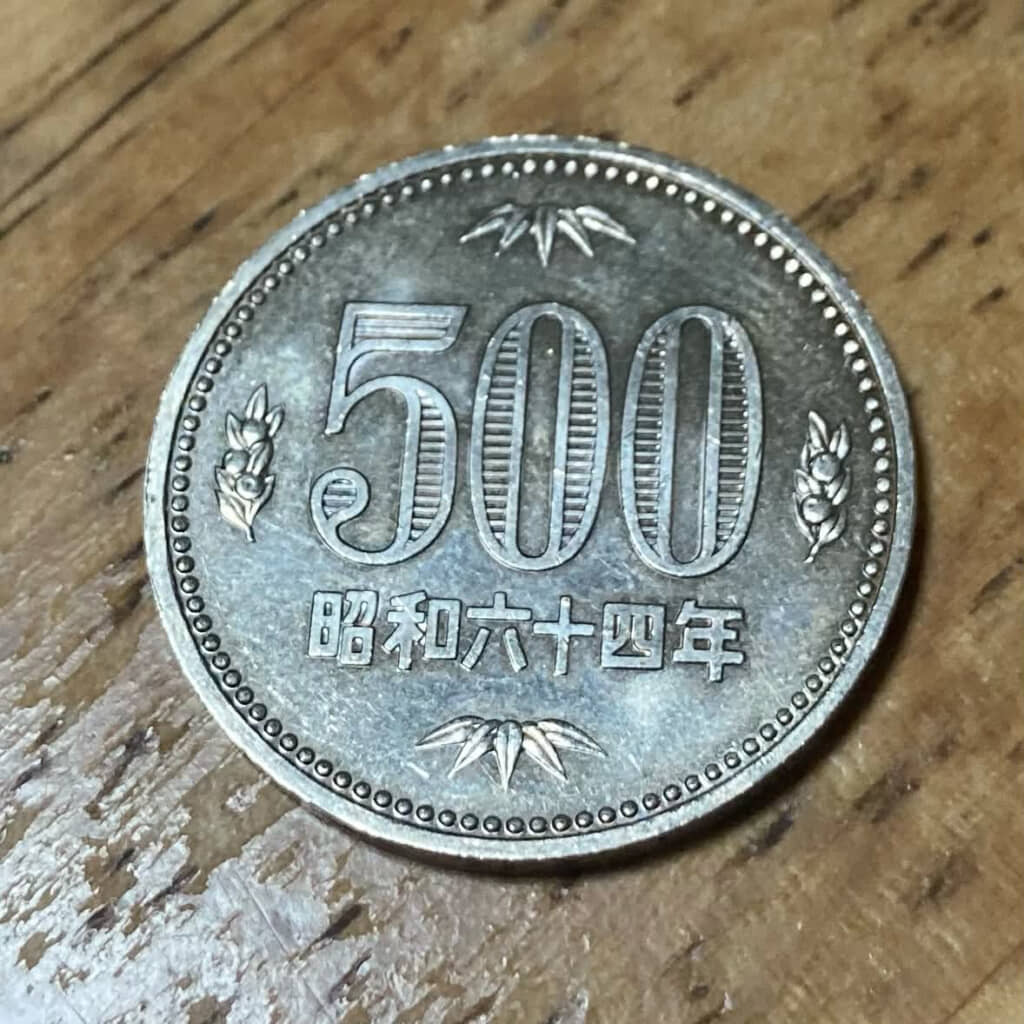 実は初代500円玉の昭和六十四年発行分。現行の3代目（五百円バイカラー・クラッド貨）の登場は令和3年（2021年）ですから、けっこうな年季