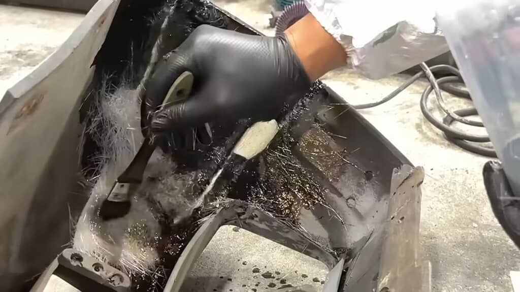 フロントバンパー内側をガラス繊維強化プラスチックで補強する様子