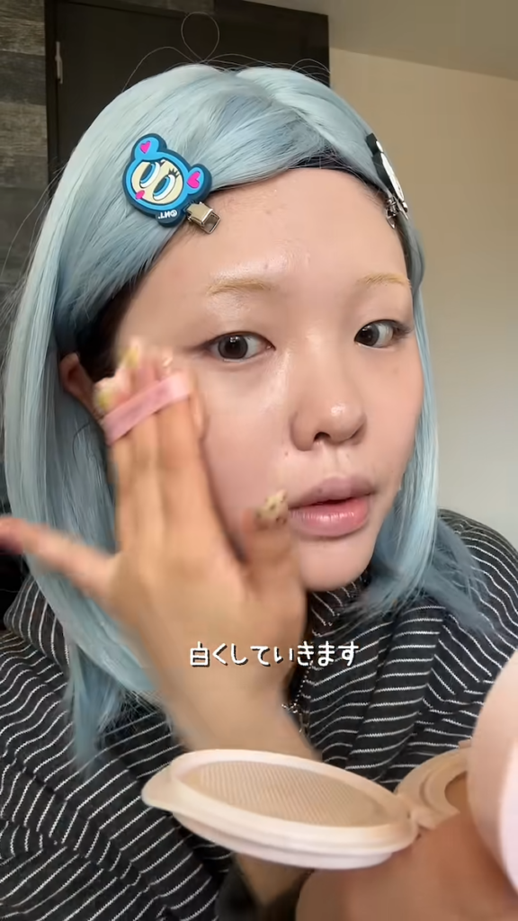 グレーのカラコンと青髪のウィッグを身に着け、ベースメイクからスタート