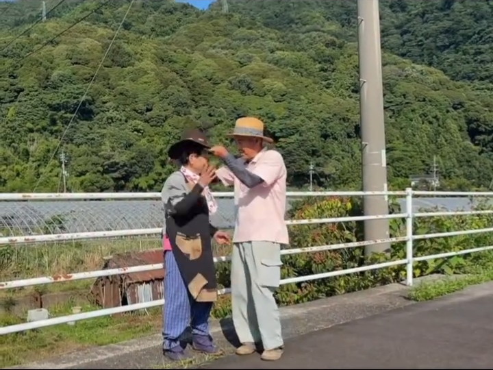 黒い帽子をかぶせるサトシさん