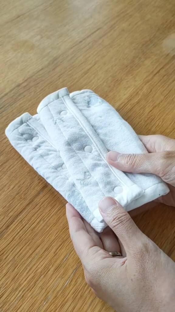 抱っこひもやベビーカーを保護できるよだれカバーが完成。ベビー服から“あわせ”の部分だけ取り出したような構造ゆえ、スナップボタンで手軽に着脱できます