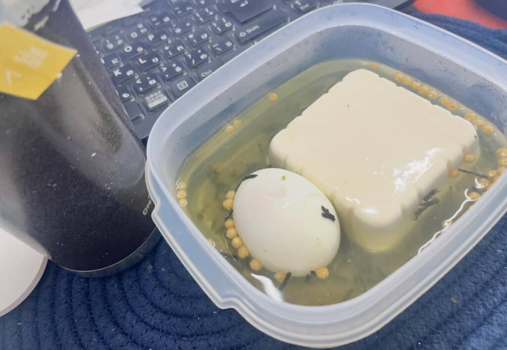(2/2)ゆで卵と豆腐にお茶漬けの素を合わせたシンプルなお弁当。タンパク質がしっかり取れて、暑い日でもさらっと食べやすいと注目を集めた